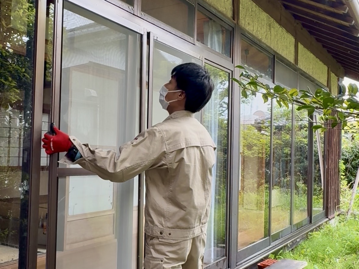 屋外で窓枠に作業する様子